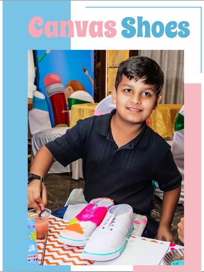 A proud young artist shows off his freshly painted canvas shoes. It's so rewarding to see the kids happy with their creations.