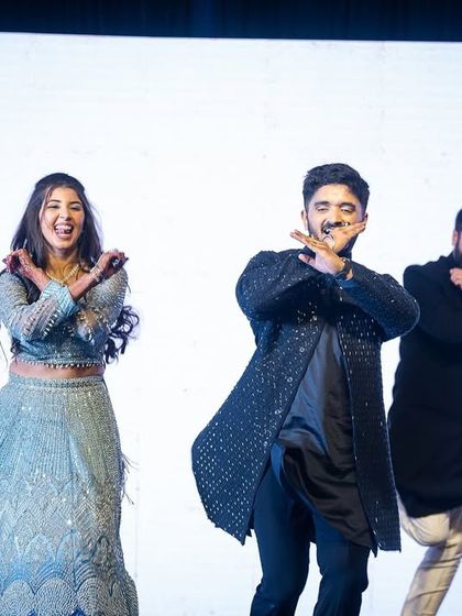 The couple joins their friends for a fun, coordinated dance move during the group performance.
