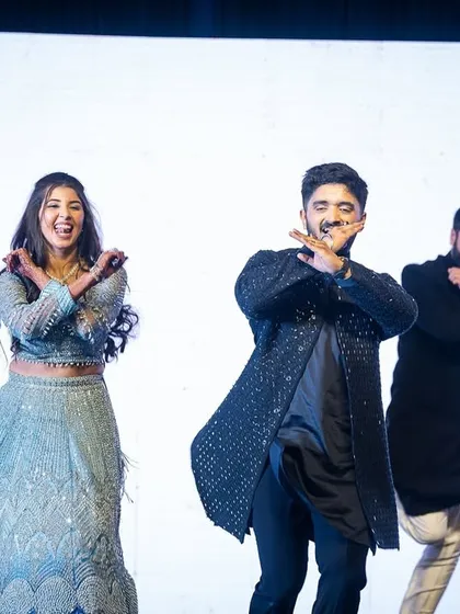 The couple joins their friends for a fun, coordinated dance move during the group performance.