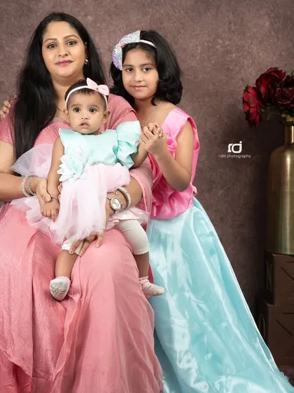 A mother's love. Here, a mom sits with her two daughters, the older one holding her hand and the baby on her lap, showing the beautiful connection between them.