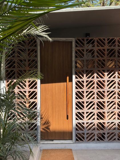 The entrance to our studio extension, where the warm wood of the door is framed by the geometric pattern of the terracotta jali. The play of sunlight through the screen creates an ever-changing, welcoming ambiance.