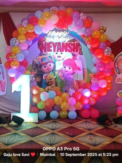 A vibrant and colorful Cocomelon theme for a first birthday party. This setup includes a full balloon arch, character cutouts, and a light-up number '1' to make your child's milestone celebration extra special and fun.