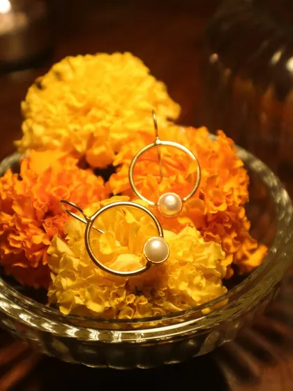 My pearl hoop earrings, shining bright amidst a bowl of fresh marigolds. A reminder that life always finds a way to expand and bloom.