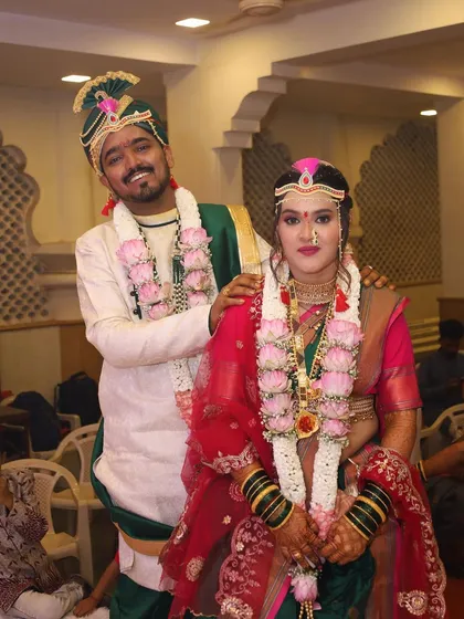 A happy couple portrait. The bride is glowing in her green and pink Paithani, a classic choice for a Maharashtrian wedding ceremony.