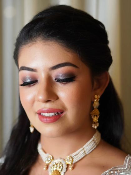 The smokey, glittering eye makeup is the focus of this shot. It's a glamorous and sophisticated choice that adds a touch of drama to any evening look.