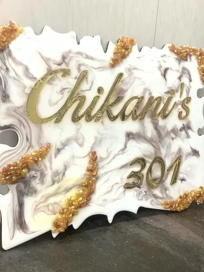 A close-up of the 'Chikani's 301' nameplate, showing the beautiful 3D gold lettering against the white and grey marble resin.