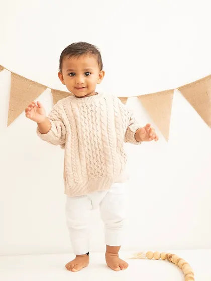 Standing tall for his first birthday. Capturing this major milestone, often with their first wobbly steps, is a key part of the celebration.