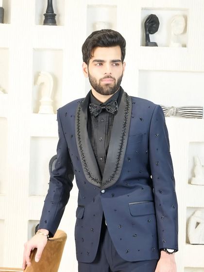 A three-quarter view of the navy blue tuxedo with beaded lapels, showing how it creates a sharp and modern silhouette.