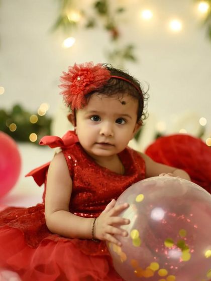 Before the cake smash, we capture some clean portraits. This little girl in her sparkly red dress looks so sweet and innocent before the messy fun begins.
