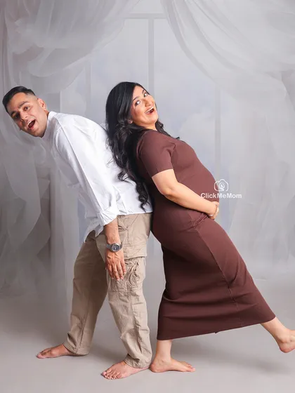Laughter and love are the best parts of this journey. This playful back-to-back pose shows the fun-loving side of this couple's relationship as they get ready to become parents.