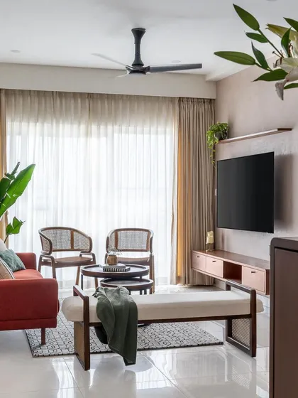 The complete living room setup in 'Living life in Colour', showcasing the blend of teak furniture, a colorful sofa, and cane chairs.