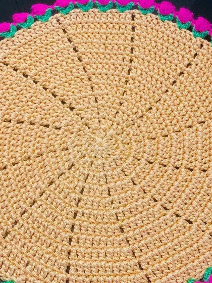 A close-up of the beige doily with a bright pink tulip border. The contrast between the neutral and the bright color is very eye-catching.