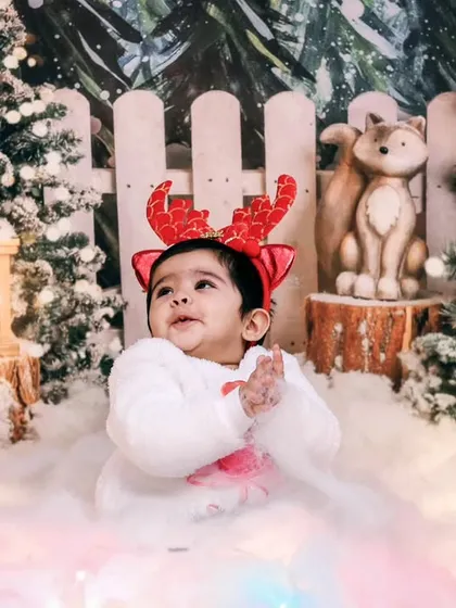 A close-up of the baby in our snowy forest set, looking up with a sweet expression.