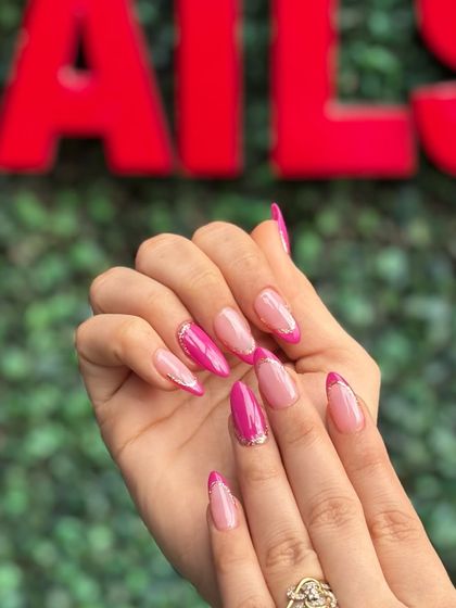 Another angle of the unapologetically pink manicure, showing off the sharp almond shape and sparkling accents.