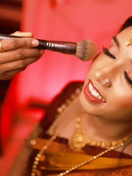 A behind-the-scenes moment of me applying finishing powder for Lavanya's engagement look, ensuring it's perfect and long-lasting.