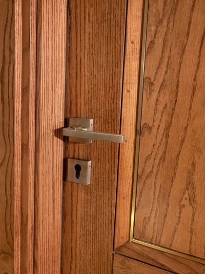 A close-up of the crown-cut ashwood veneer door, highlighting the metal inlay and the rich texture of the wood.