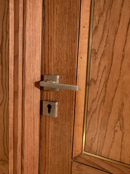 A detail shot of the ashwood door, showing the clean lines of the metal inlay and the quality of the hardware. Every element is chosen with care.