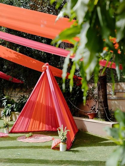 Another view of the garden tent, a simple and playful addition to the Haldi festivities. The bright pink and orange fabrics stand out beautifully against the lush green lawn.
