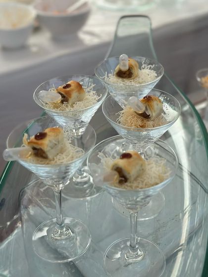 An elegant dessert presentation in martini glasses. This dish features layers of texture and flavour, with a delicate pastry and creamy filling.