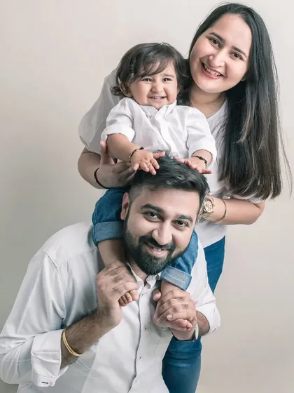 A playful moment on dad's shoulders. This family portrait is full of life and energy, showcasing the fun and loving dynamic between them.