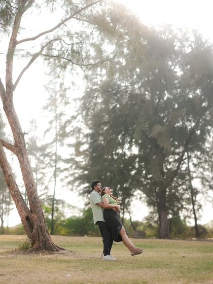 A playful and romantic moment captured in a beautiful, sunlit park. The way he lifts her up feels spontaneous and joyful. This is a perfect example of how I direct couples to interact naturally for authentic photos.