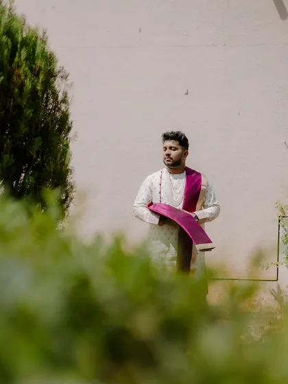 A candid portrait of the groom, captured in a quiet moment of reflection before the ceremony begins.
