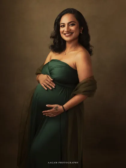 Her hand rests lovingly on her bump, a classic and heartfelt gesture. This portrait is a simple, beautiful celebration of the maternal bond.
