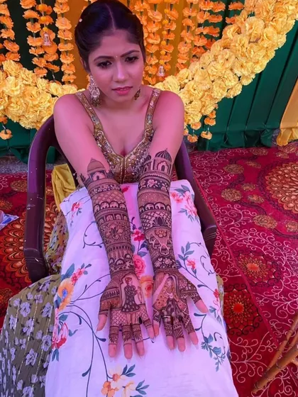 A close-up shot of the bride's hands, highlighting the detailed portrait work and the symmetry of the overall design.