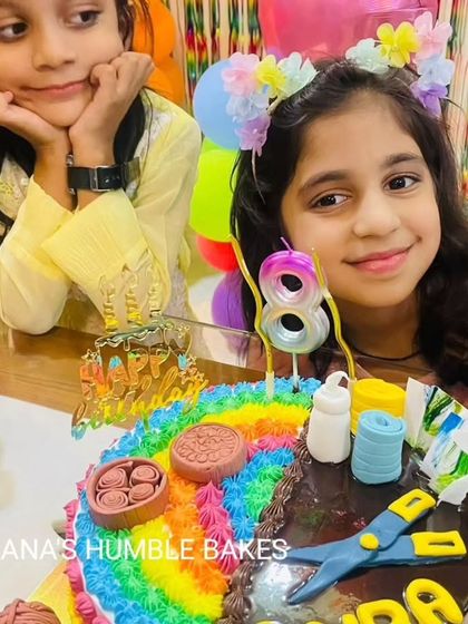 The birthday girl and her friend admiring the half-and-half art and craft cake.