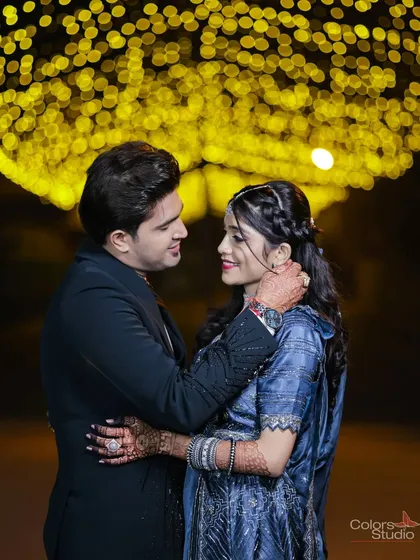 A romantic couple portrait under a canopy of fairy lights. The beautiful bokeh effect creates a dreamy, intimate atmosphere perfect for a reception shoot.