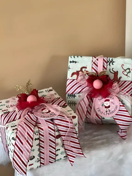 Santa's first Christmas! These beautifully wrapped gifts are perfect for a baby's first holiday season, with festive paper and big, cheerful bows.
