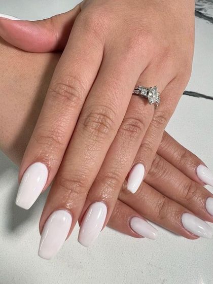 A flawless set of milky white coffin-shaped nails. This clean, chic, and modern look is a popular choice for brides.