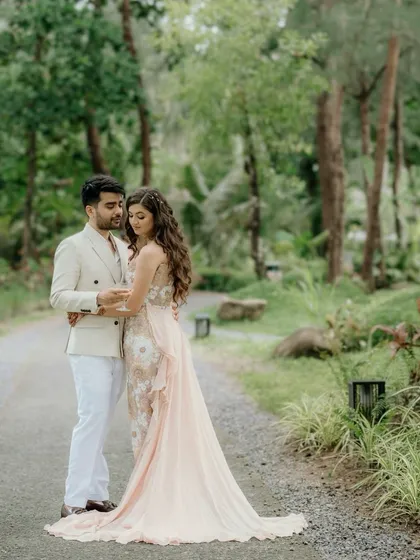 A romantic portrait of the couple at their pool party. The soft, natural lighting and lush green background create a serene atmosphere, focusing on their gentle embrace.