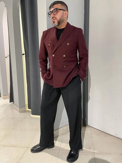 A full-length view of the burgundy jacket paired with wide-leg black trousers, a personal look that blends classic tailoring with modern proportions.