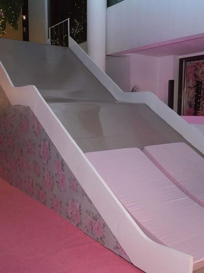 A custom-built slide for the bachelorette party, decorated with floral-print wallpaper, adding a touch of playful fun to the elegant event.