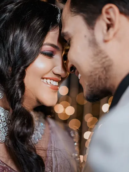 A tight, romantic close-up showing the couple's happy expressions and the beautiful bokeh from the background lights.