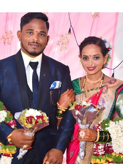 A happy couple on their wedding day. He chose a classic blue reception suit from our collection to coordinate with his bride's traditional saree.