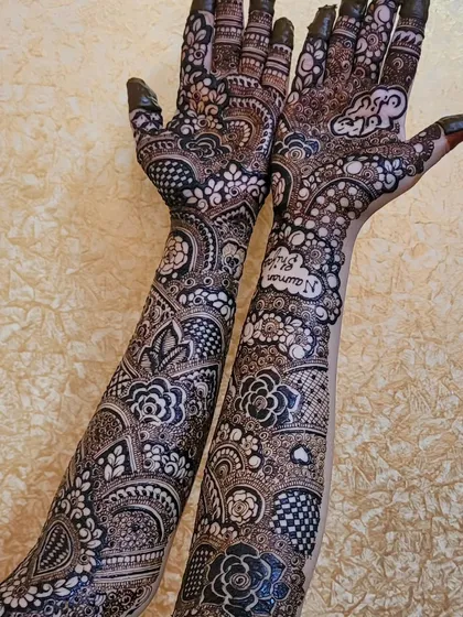 This is a full bridal design that goes all the way up the arms, combining bold floral motifs with delicate, intricate patterns. I also included the names Nauman and Shifa in the palms to make it a unique part of their story.