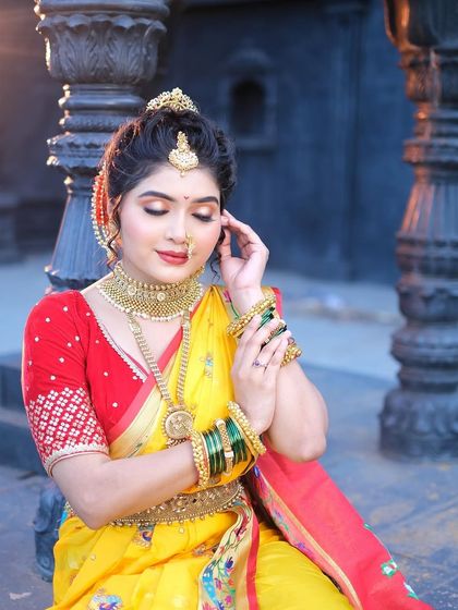 A classic Maharashtrian bridal look. The bright yellow Navuari saree is draped in the traditional style, complete with a nath and green bangles.