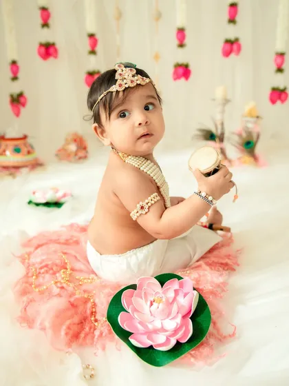 A baby Krishna holding a small drum. Incorporating different props keeps the session engaging and allows for a variety of unique portraits.