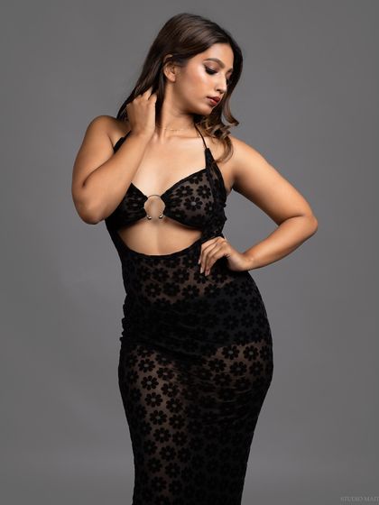 A full-body shot of the model in the sheer black floral dress, showing its length and design.