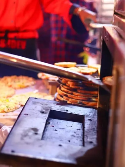 A shot of our team baking fresh pizzas in a portable oven. We offer a live pizza counter where guests can enjoy hot, oven-baked pizzas with their choice of toppings.