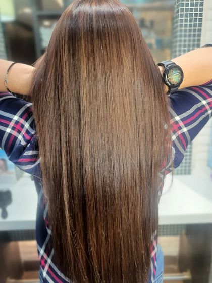 This long, healthy hair is enhanced with a rich brown global color, giving it a glossy, polished finish from root to tip.