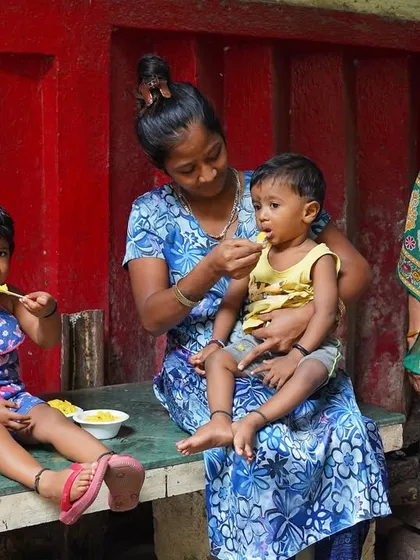 A mother feeding her child a meal provided by our Annam Brahma initiative. Every meal we serve is more than just food; it is love, dignity, and hope on a plate.