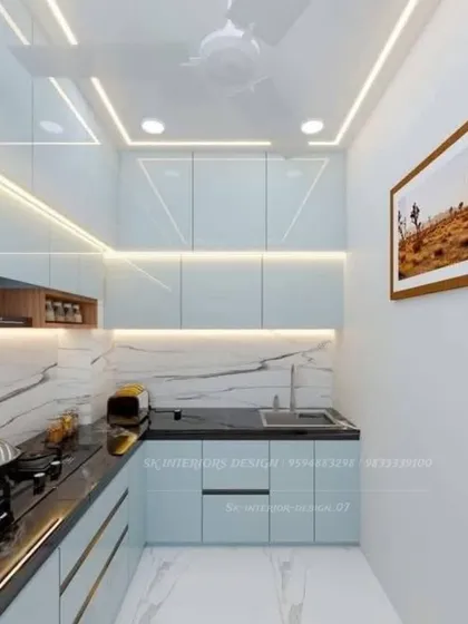 A parallel kitchen with light blue cabinets and a black granite countertop. The marble-patterned backsplash and profile lighting under the cabinets create a sophisticated look.