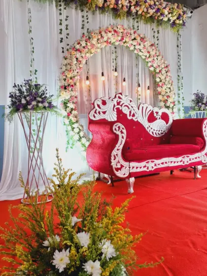 This angle captures the lush floral arrangements and hanging Edison bulbs that add a modern touch to the classic stage design.