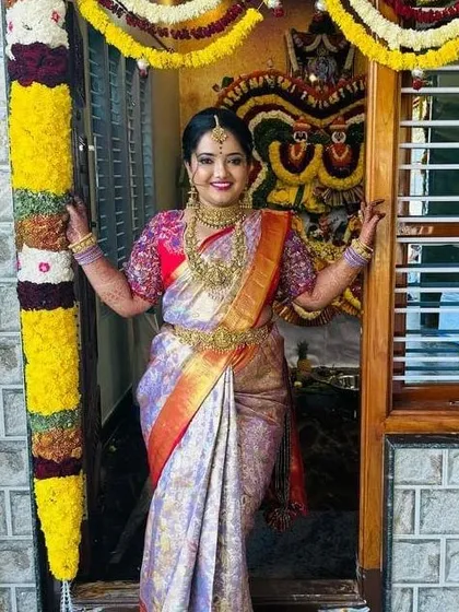 There is nothing more rewarding than seeing a client's joyous smile. This beautiful bride is celebrating in her custom-stitched Kanchipuram silk saree and a blouse with dense, multi-colored floral embroidery on the sleeves.