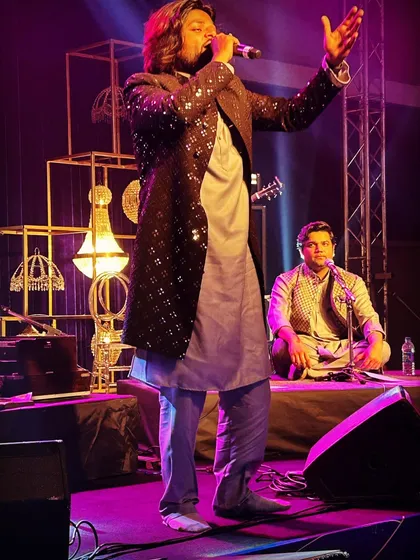 A powerful stance during a live show. Even when standing, we bring the same soulful intensity and connection to the lyrics, as seen in this expressive photograph.