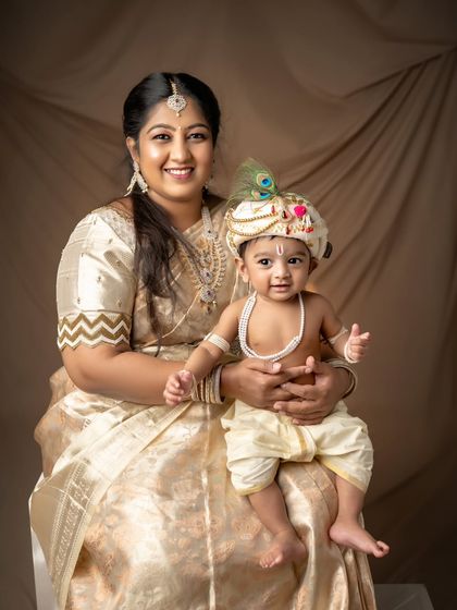 A mother and her little Krishna, both smiling brightly for the camera.