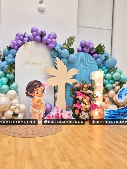 The full setup for the Moana first birthday, showing the custom backdrop, character cutouts, and balloon arch.